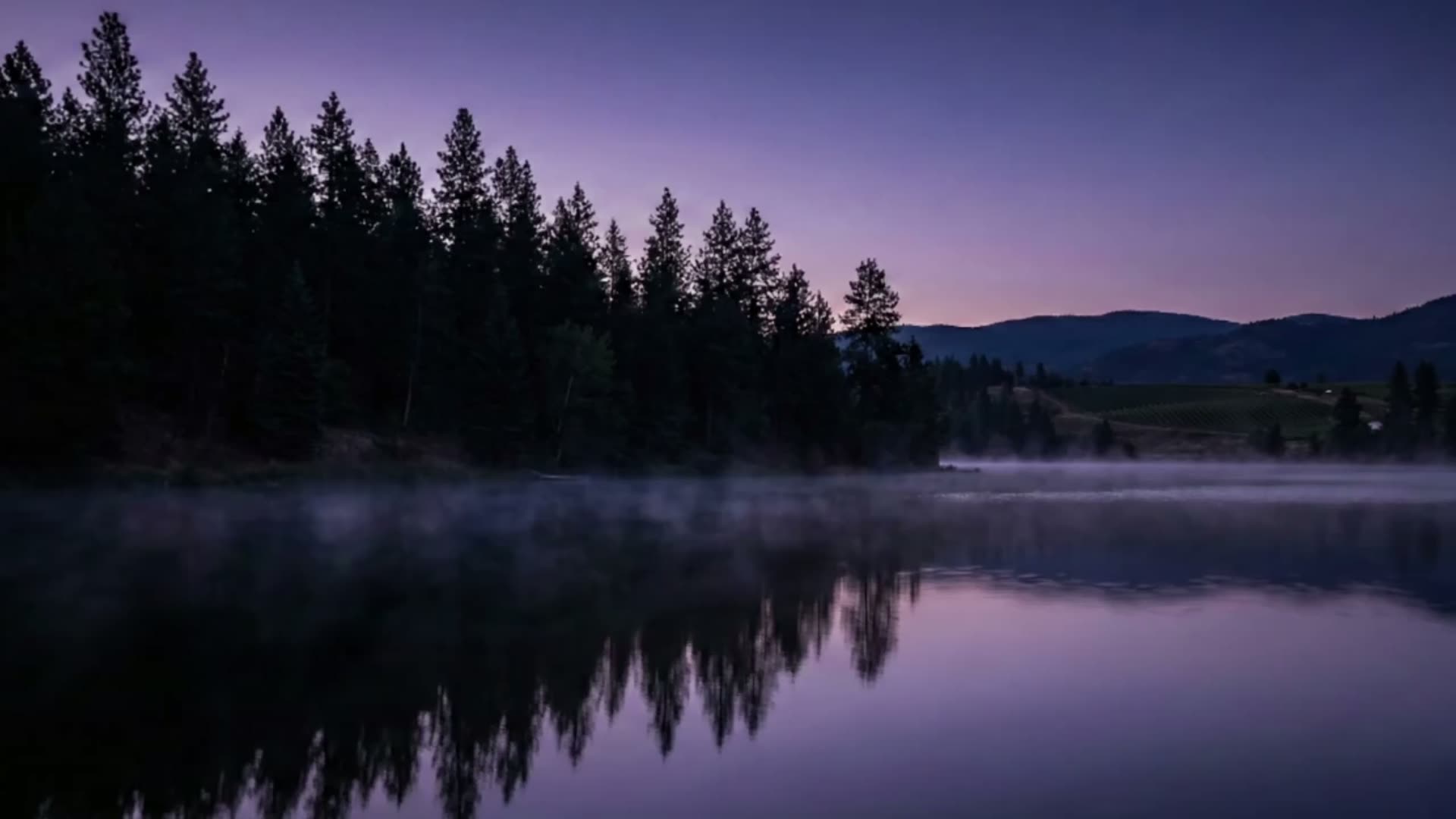Mist drifting over an Okanagan lake at dusk