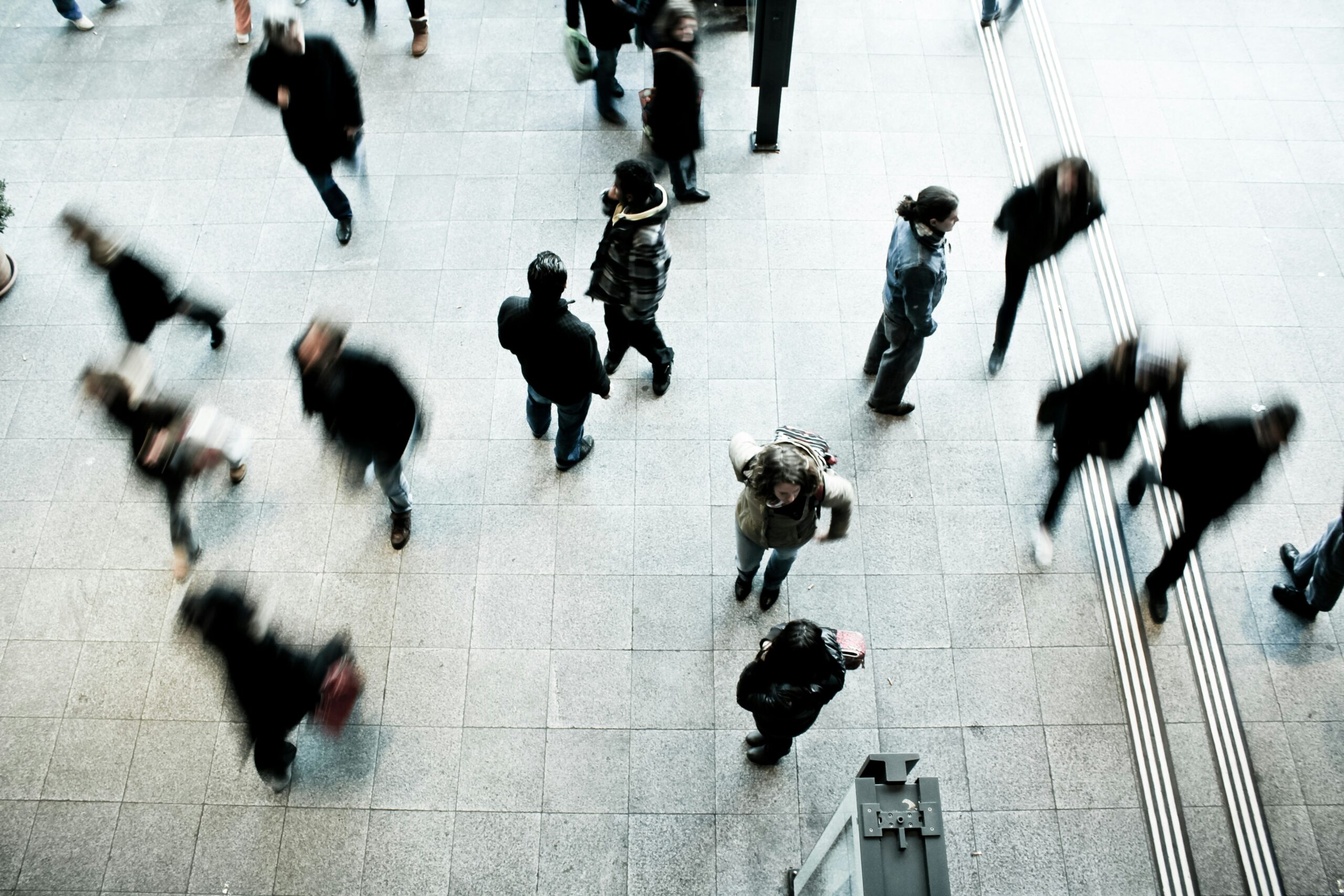 A crowd moving through a bright public space